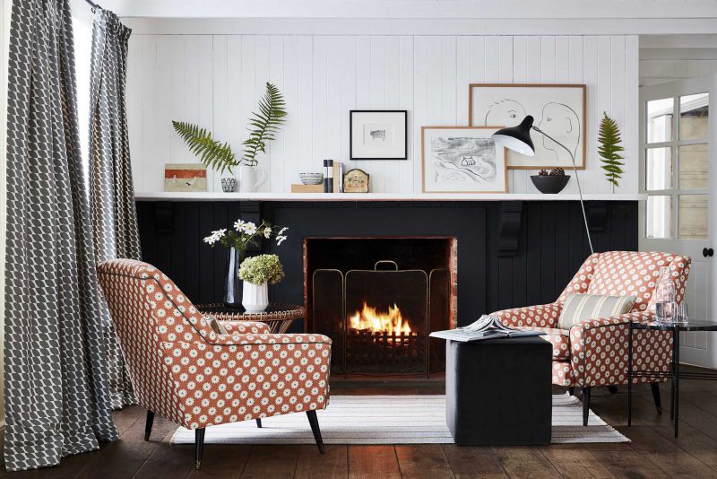 fabric covered armchairs by a fireplace